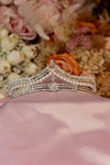 Silver bridal tiara with pearl strands, pavé rhinestone rails and starburst centre crystal on pink satin — Feriha Bridal
