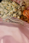 Silver bridal tiara with pearl strands, pavé rhinestone rails and starburst centre crystal on pink satin — Feriha Bridal
